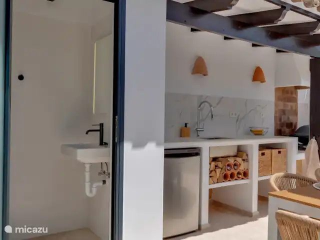 Naast het terras en de buitenkeuken is hier ook een buiten toilet aanwezig voorzien van wastafel en spiegel